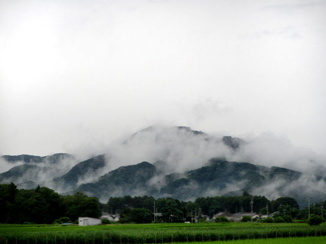 煙る山